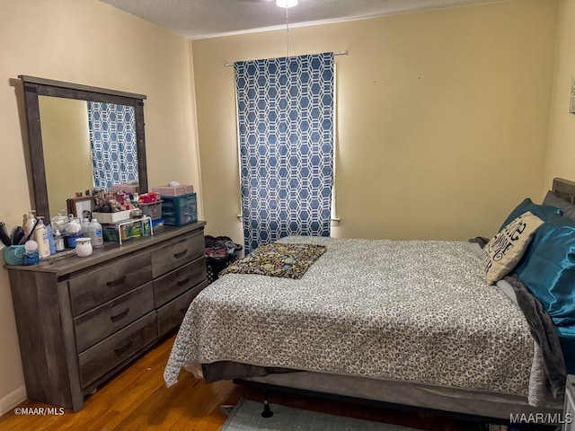 bedroom with a textured ceiling and hardwood / wood-style flooring