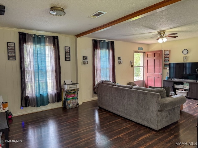 living room featuring a textured ceiling, ceiling fan, and dark hardwood / wood-style floors