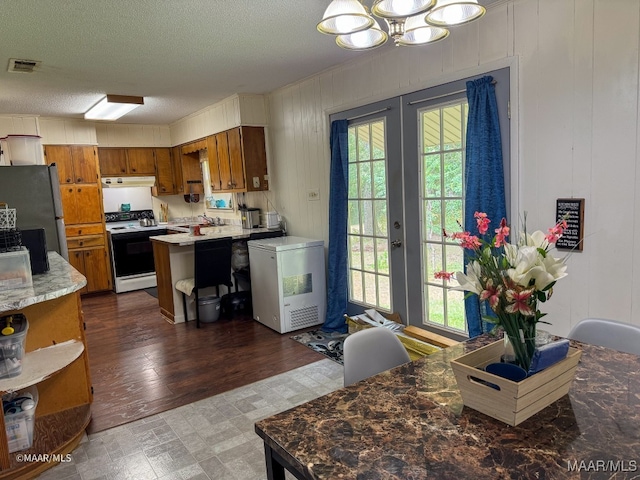 kitchen featuring stainless steel fridge, a notable chandelier, dark wood-type flooring, fridge, and white range with electric cooktop