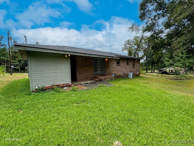 back of property featuring a yard and central air condition unit