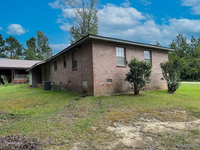 view of home's exterior with a lawn and central AC