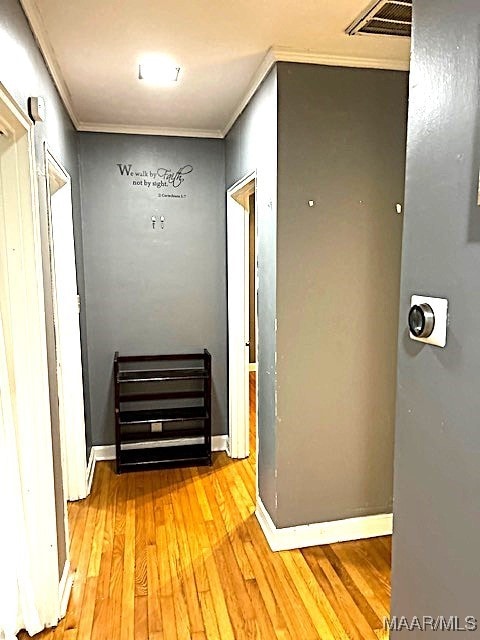 hall featuring crown molding and light hardwood / wood-style flooring