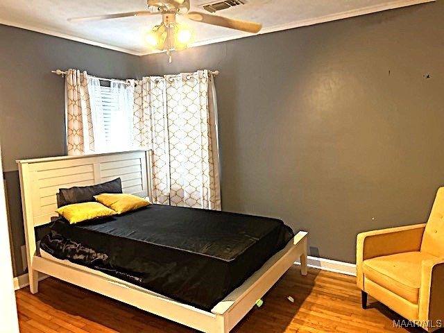 bedroom with ornamental molding, hardwood / wood-style floors, and ceiling fan