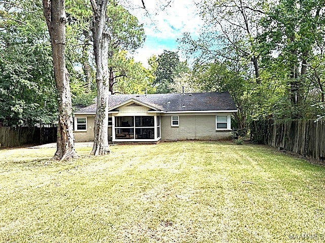 rear view of property featuring a lawn