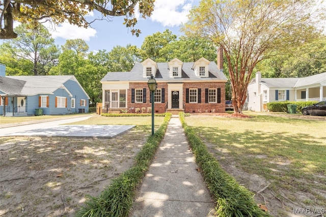 new england style home featuring a front lawn