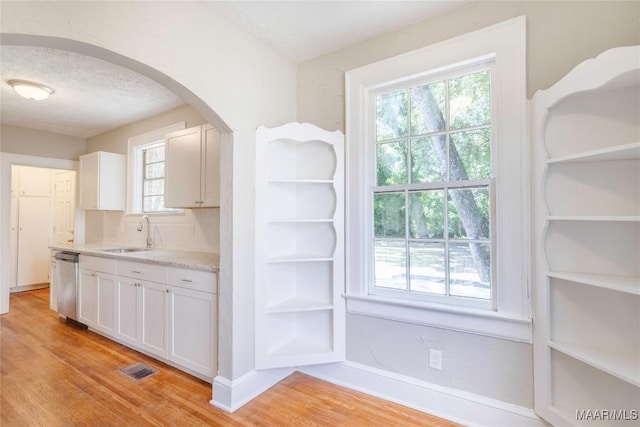 2056 Gorgas St, Montgomery, AL 36106 - kitchen featuring arched walkways, light wood-style flooring, stainless steel dishwasher, and a sink