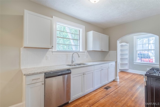 kitchen with appliances with stainless steel finishes, light hardwood / wood-style floors, white cabinetry, and sink