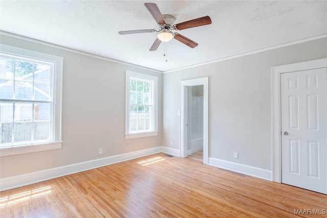 empty room featuring ceiling fan, light hardwood / wood-style floors, crown molding, and a textured ceiling