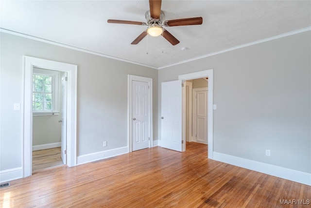 unfurnished bedroom with light hardwood / wood-style flooring, ceiling fan, and ornamental molding