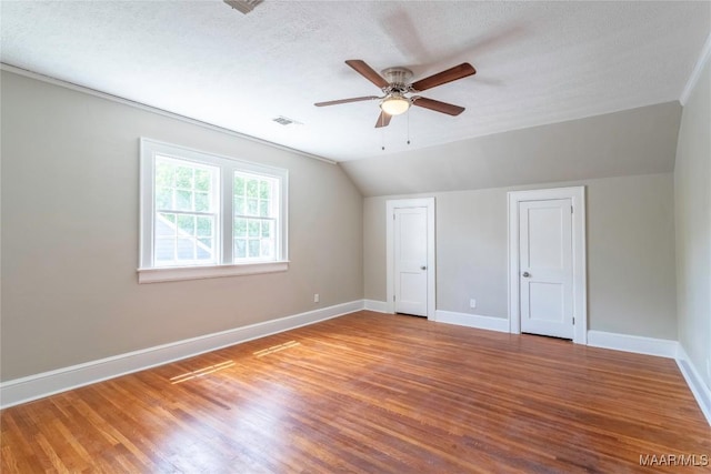 2056 Gorgas St, Montgomery, AL 36106 - unfurnished bedroom featuring visible vents, a textured ceiling, wood finished floors, baseboards, and vaulted ceiling