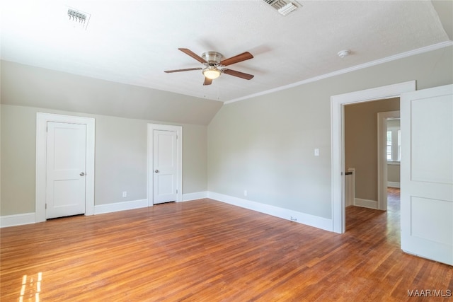 empty room featuring ceiling fan, hardwood / wood-style flooring, ornamental molding, and a textured ceiling