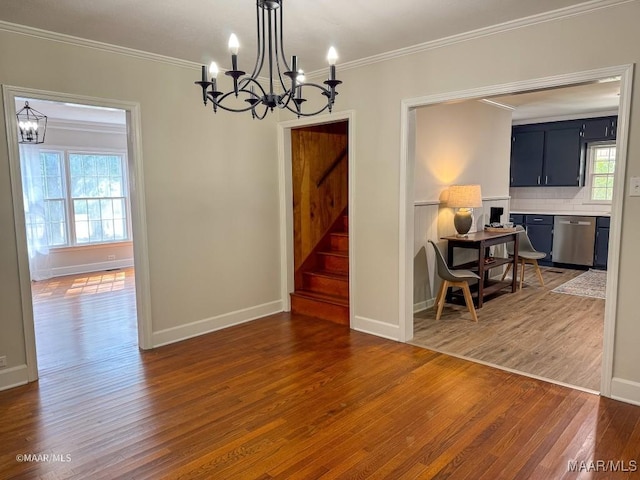 dining space with stairway, wood finished floors, a notable chandelier, and ornamental molding