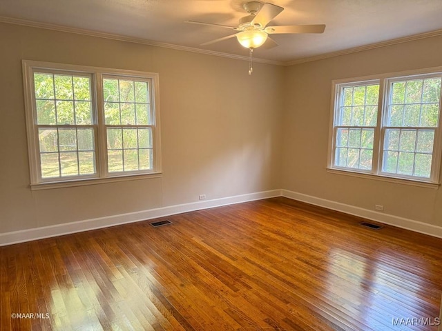 empty room with visible vents, dark wood-style floors, and crown molding