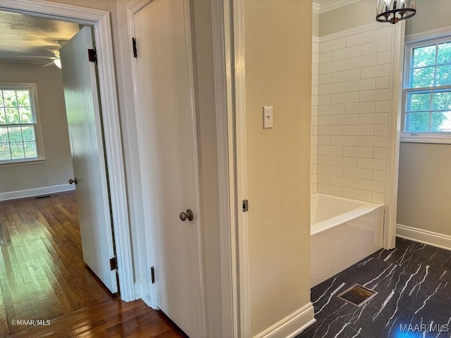 full bath with visible vents, baseboards, shower / washtub combination, and wood finished floors