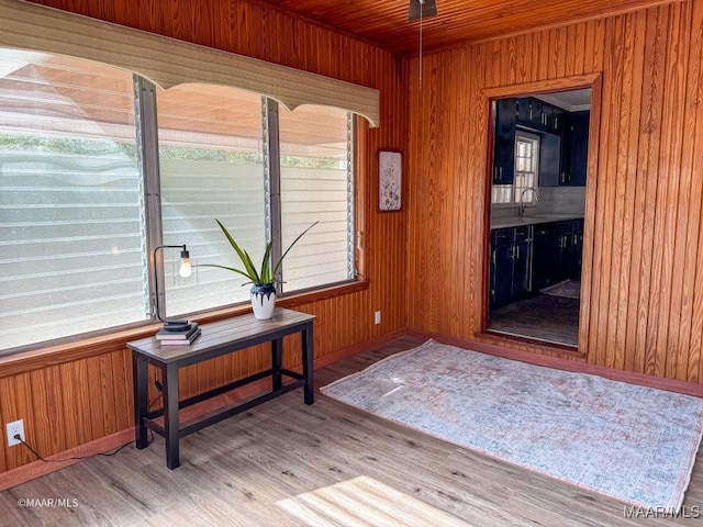 interior space featuring a sink, wood finished floors, wood ceiling, and wood walls