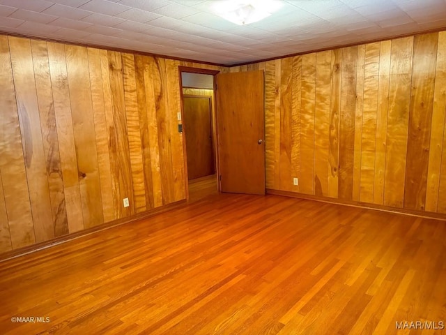 unfurnished room featuring wooden walls and wood finished floors