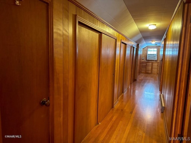 hallway with lofted ceiling and light wood-style floors