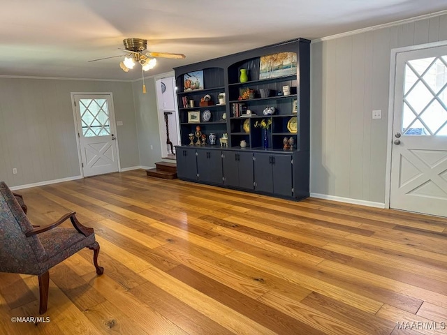 living room featuring plenty of natural light, crown molding, baseboards, and hardwood / wood-style flooring