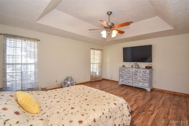 145 Cotton Ln, Deatsville, AL 36022 - bedroom featuring baseboards, a textured ceiling, and a tray ceiling
