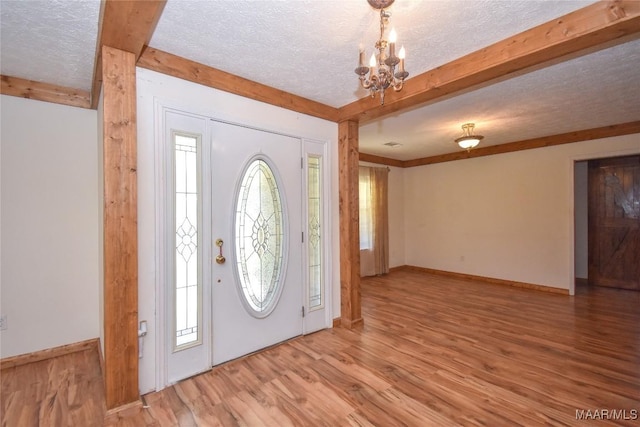 145 Cotton Ln, Deatsville, AL 36022 - foyer with an inviting chandelier, wood finished floors, beamed ceiling, baseboards, and a textured ceiling