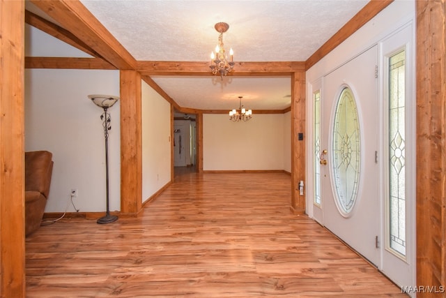 entryway featuring a textured ceiling, a chandelier, and light hardwood / wood-style flooring