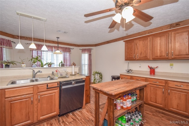 kitchen featuring hardwood / wood-style floors, sink, black dishwasher, ceiling fan, and a textured ceiling