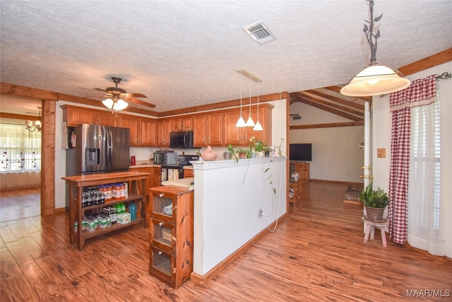 kitchen featuring light wood-type flooring, ceiling fan with notable chandelier, stainless steel fridge, and a textured ceiling