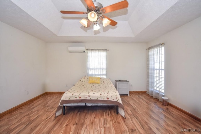 145 Cotton Ln, Deatsville, AL 36022 - bedroom with multiple windows, a wall mounted AC, and a tray ceiling