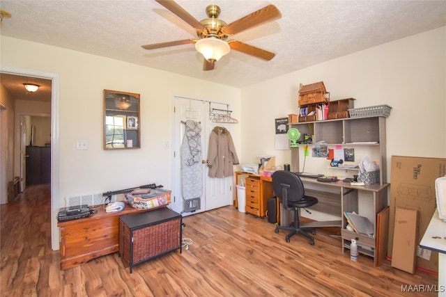 home office featuring a textured ceiling, hardwood / wood-style floors, and ceiling fan