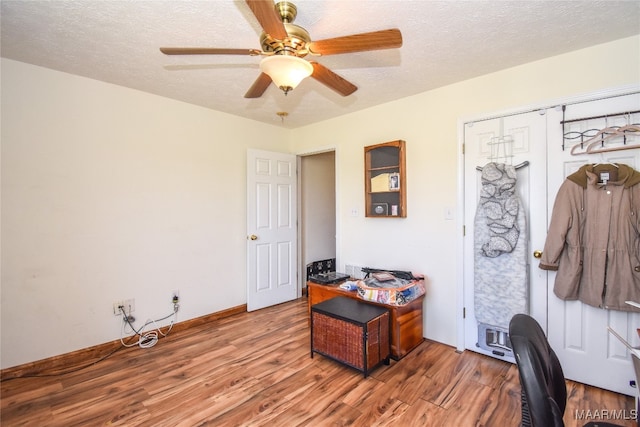 home office with a textured ceiling, hardwood / wood-style flooring, and ceiling fan