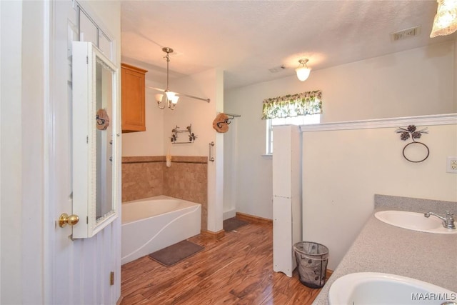 145 Cotton Ln, Deatsville, AL 36022 - full bathroom with a sink, a bath, wood finished floors, and visible vents