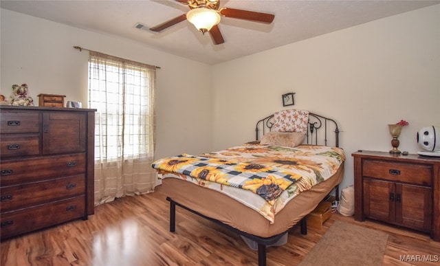 bedroom with light hardwood / wood-style flooring and ceiling fan