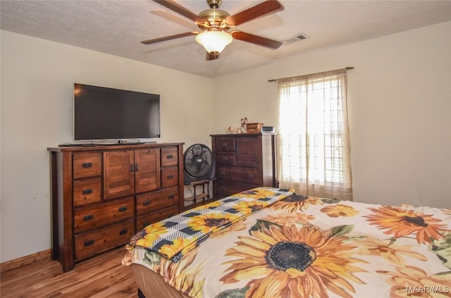 145 Cotton Ln, Deatsville, AL 36022 - bedroom with baseboards, a ceiling fan, wood finished floors, and visible vents