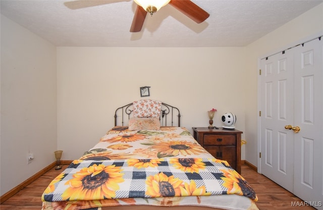 bedroom featuring a textured ceiling, light hardwood / wood-style flooring, ceiling fan, and a closet