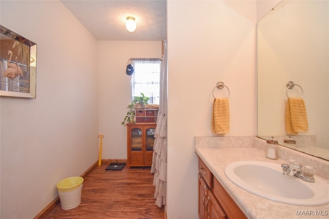 bathroom with hardwood / wood-style floors, a textured ceiling, and vanity