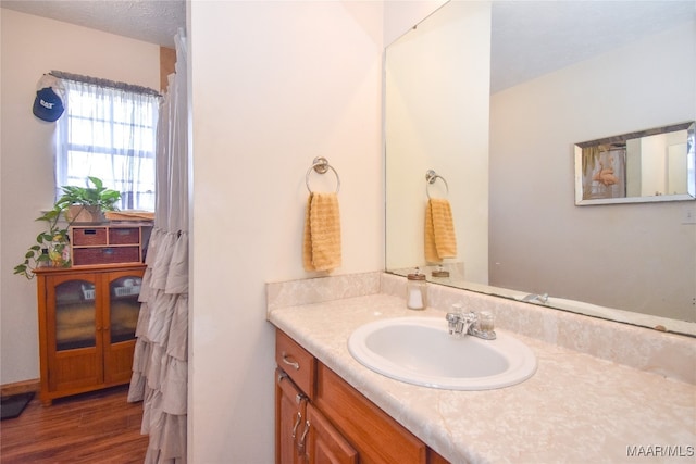 bathroom with a textured ceiling, vanity, and hardwood / wood-style floors