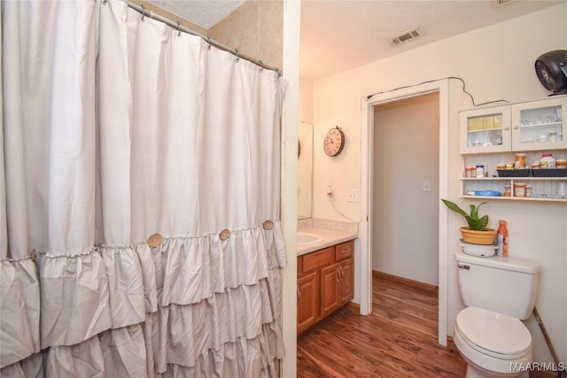 145 Cotton Ln, Deatsville, AL 36022 - full bath featuring vanity, toilet, wood finished floors, a shower with curtain, and visible vents