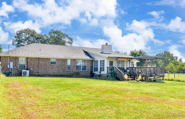 rear view of house featuring central AC unit, a yard, and a wooden deck