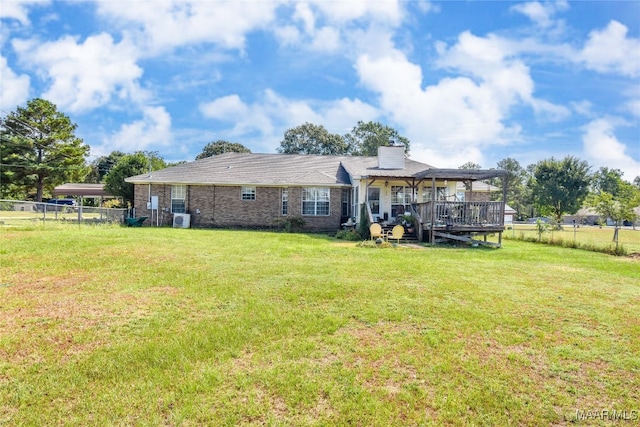 back of property with a deck and a lawn