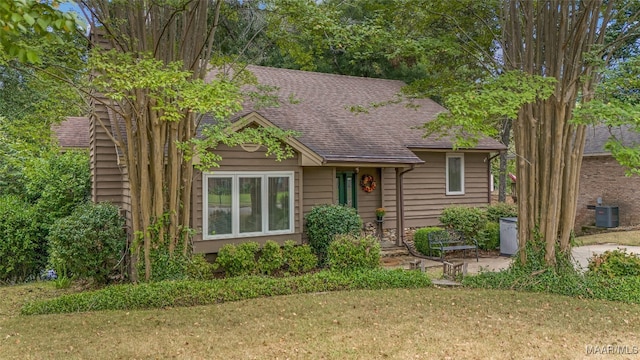 view of front of property featuring a front lawn and central AC