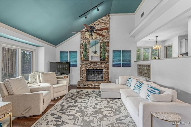 living room featuring wood-type flooring, ceiling fan with notable chandelier, a fireplace, rail lighting, and high vaulted ceiling