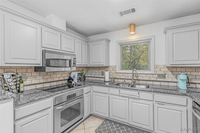 kitchen with white cabinets, appliances with stainless steel finishes, and sink