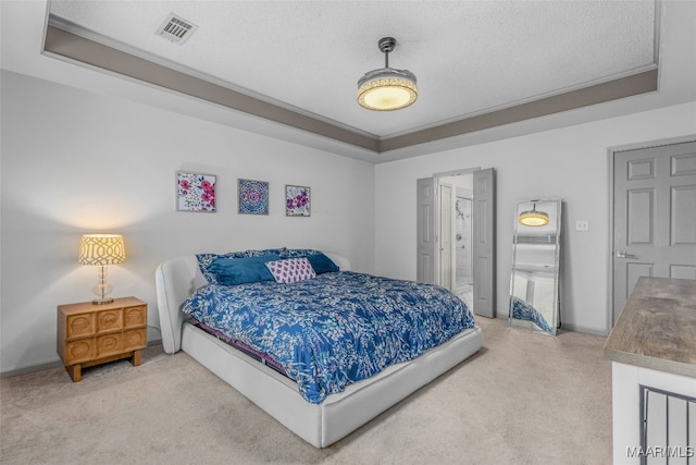 bedroom featuring a textured ceiling, a raised ceiling, and carpet