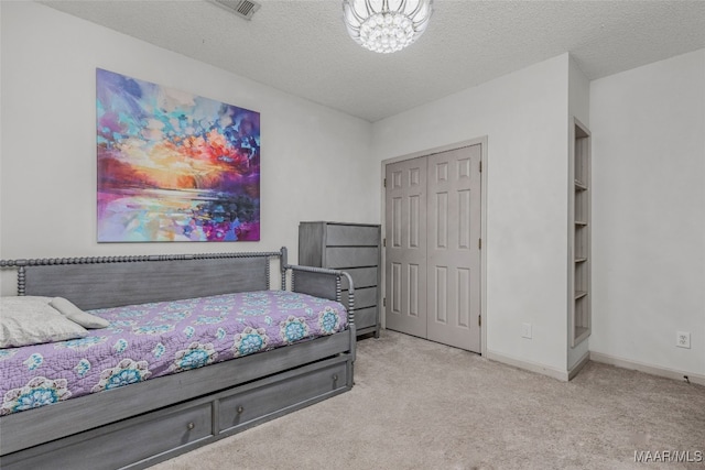 carpeted bedroom featuring a closet and a textured ceiling