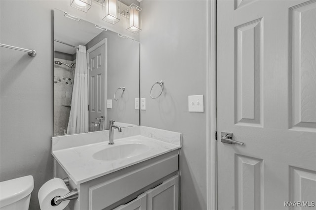 bathroom with walk in shower, vanity, and toilet