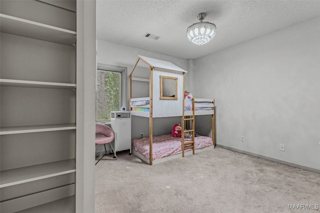 carpeted bedroom featuring a textured ceiling