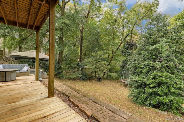 wooden deck with a trampoline and a gazebo