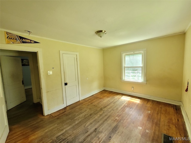 unfurnished room with crown molding and wood-type flooring