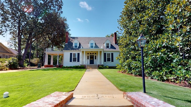 new england style home with covered porch and a front lawn