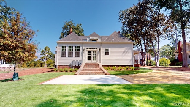 rear view of house with a lawn and french doors